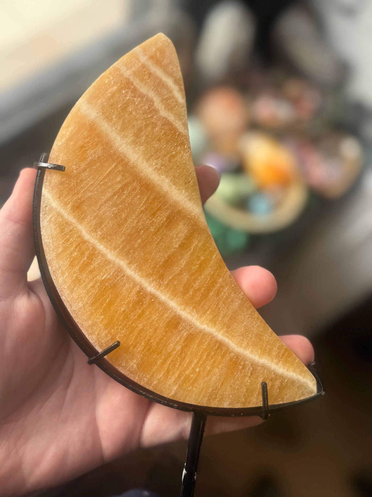 orange calcite moon on stand
